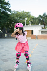 Fototapeta premium smiling 5 year old asian girl going on her in-line skates