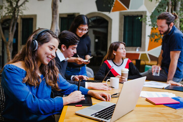 Young latina businesswoman with headphones on video conference at workplace in Mexico