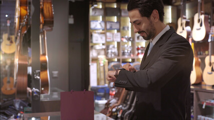 An upwardly mobile Muslim man using smart payment to pay for a product at a sale terminal with nfc identification payment for verification and authentication