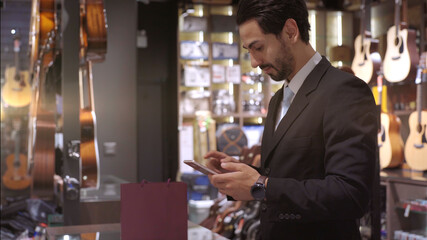 An upwardly mobile Muslim man using smart payment to pay for a product at a sale terminal with nfc identification payment for verification and authentication