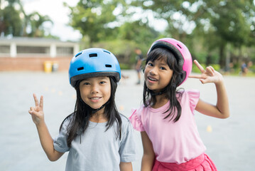 two asian girl going on her in-line skates in the park