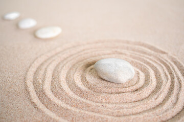 Fototapeta na wymiar Japanese zen garden stone on wave sand beach. rock or pebbles with copy space. for aroma therapy spa on summer holidays. meditation wellness and tranquility Japanese concept.