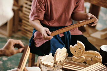 Team of carpenters making making edge grain cutting boards and toy out of high quality wood in...