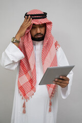 an arab in a turban is dizzy while using a pad on a plain background