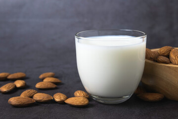 Milk with almonds nut on dark background copy space organic healthy concept.