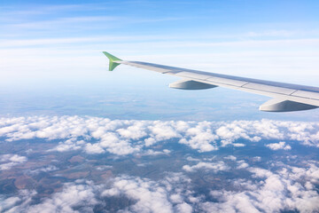 View from the airplane window at a beautiful blue sunrise and the airplane wing above the clouds.