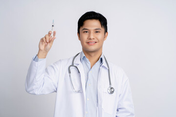 Portrait of a handsome Asian male doctor holding a syringe on isolated background.