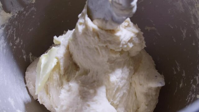 4K Close up bread dough making process by using flour mixing machine. Machine knead bread dough. Homemade bread raw mix with small machine. Food concept.