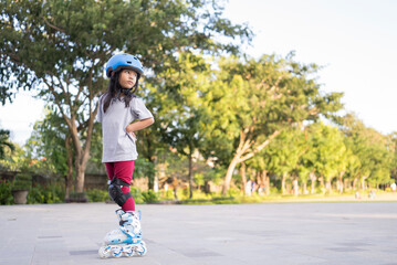 smiling 5 year old asian girl going on her in-line skates