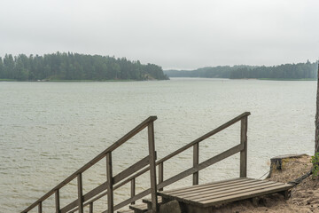 Wooden stairs to the seashore. Sandy beach, pine forest. Scandinavian nature. Finland. Porvoo