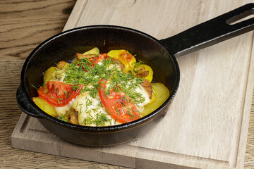 Roasted potatoes with vegetables and spices in a frying pan. Whole dinner in a frying pan