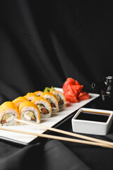 Sushi Rolls with processed cheese cheddar, american cheese, avocado, tuna and cream cheese inside on white slate