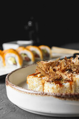 Tuna sushi in white dish served with soy and wasabi sauce, pickled ginger. Sushi set with tuna shavings on top.