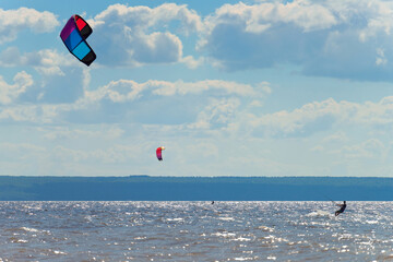 Kiteboarder surfing waves with kiteboard on a sunny summer day.