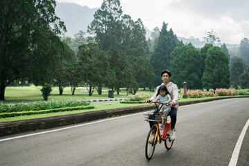 Obraz premium asian Older brother take his sister on fun bike riding in the park