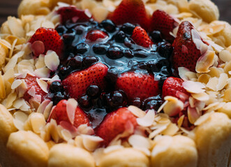 Close-up of a festive berry cake decorated with Savoyardi cookies.