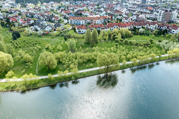 aerial view of summer cityscape with residential houses, green park and beautiful river