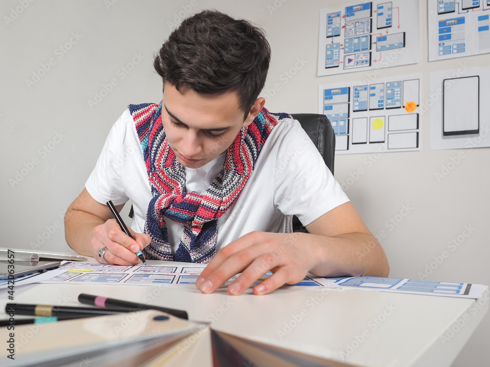 Poster apps developer at runtime. guy works in apps developer. he draws app layouts on paper. guy surrounde