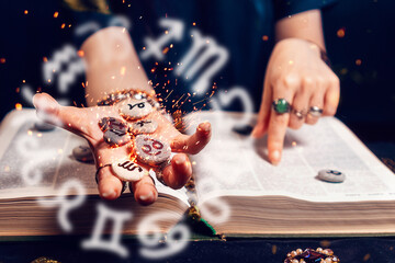 Astrology and horoscope. Fortune teller's hand holds the sparkling zodiac stones in the palm of her...