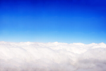 Aerial view from the aircraft to clouds in the blue sky