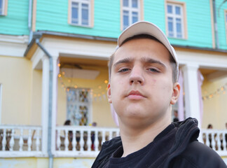 Young handsome autistic guy on a walk in the city. Looks at the camera