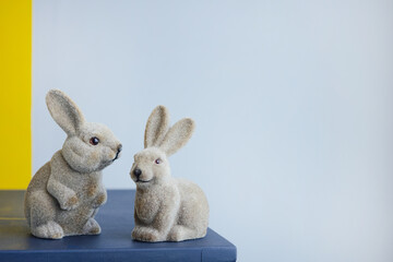 Ceramic easter hares, vintage figurine rabbit on a gray wall background with copyspace