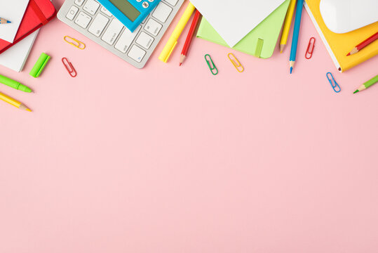 Top view photo of keyboard mouse multicolor pencils pens clips red green and yellow diaries and calculator on isolated pastel pink background with copyspace