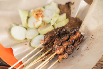 chicken satay skewer with rice cake. sate ayam lontong street food