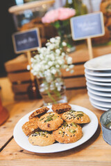 Fresh cereal cookies in a plate on a wooden table.