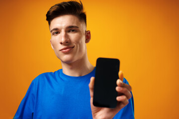 Young handsome man showing black smartphone screen