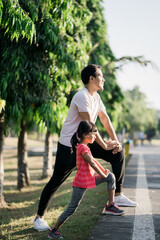 Obraz premium asian father and daughter stretching and sport outdoor together in the park