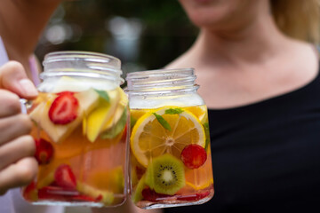 two young women toast to health with detox drinks. Selective Focus Glasses