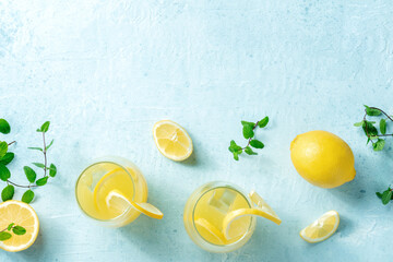 Lemonade. Homemade fresh lemon ice tea, shot from the top with copy space on a blue background. A...