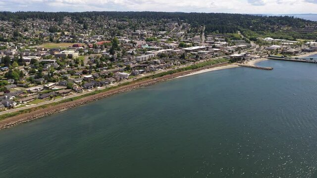 Cinematic 4K dolly in drone clip of downtown Edmonds, the commercial area, Kingston ferry terminal waterfront marina, shoreline near Seattle, Washington, Pacific Northwest, in Snohomish County