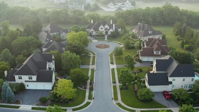 Aerial dolly shot of mansions in upscale residential home development. Cal de sac street with circular drive. Residential gated country club community.