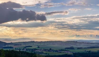 View to summer Czech valley landscape with small vilage Besednice at sunset cloudy sky