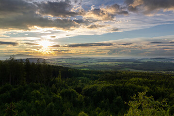 Summer forest Czech valley landscape with small vilage Besednice at sunset cloudy sky