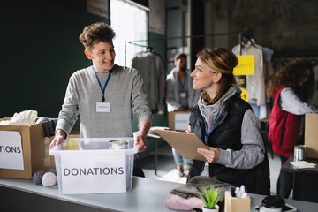 Group of volunteers working in community charity donation center, talking.
