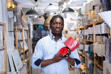 Man chooses a table lamp in an electrical store