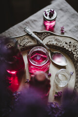 pink lilac syrup in jars on a plate with lilac flowers