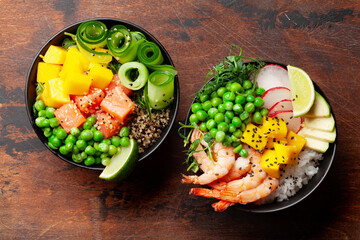 Poke bowls with shrimps, salmon, avocado and mango