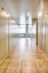 Architecture Concepts. Indoors View of Long Industrial Tile Corridor With Metal Lockers.