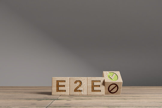 Wood cubes with acronym 'E2E' - 'End 2 End Processes' on a beautiful wooden table, studio background. Business concept and copy space.
