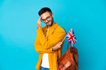 Young caucasian man holding an United Kingdom flag isolated on yellow background with headache