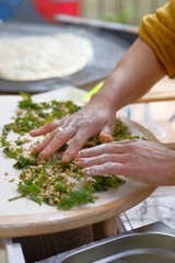 Turkish woman prepares traditional dishes at home kitchen.