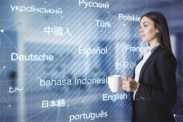 E-learning. Attractive young european businesswoman with coffee cup standing in blurry office...