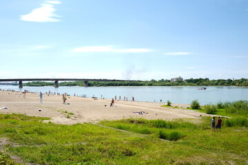 Fototapeta na wymiar The central city beach on the banks of the Irtysh River overlooking the Leningradsky Bridge. Omsk, Siberia, June 27, 2021.