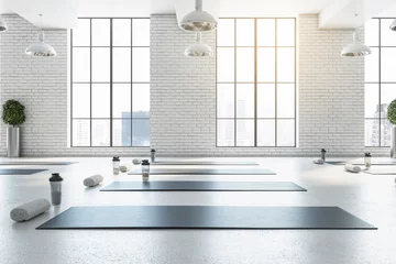  Stijlvol helder wit yogastudio gym interieur met bakstenen muur, raam en uitzicht op de stad. 3D-rendering. © Who is Danny
