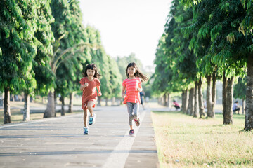 Fototapeta na wymiar two Asian girl is jogging in the park in the morning