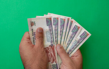 Egypt national currency. Money banknotes. Man hands hold egyptian pound banknotes on green...